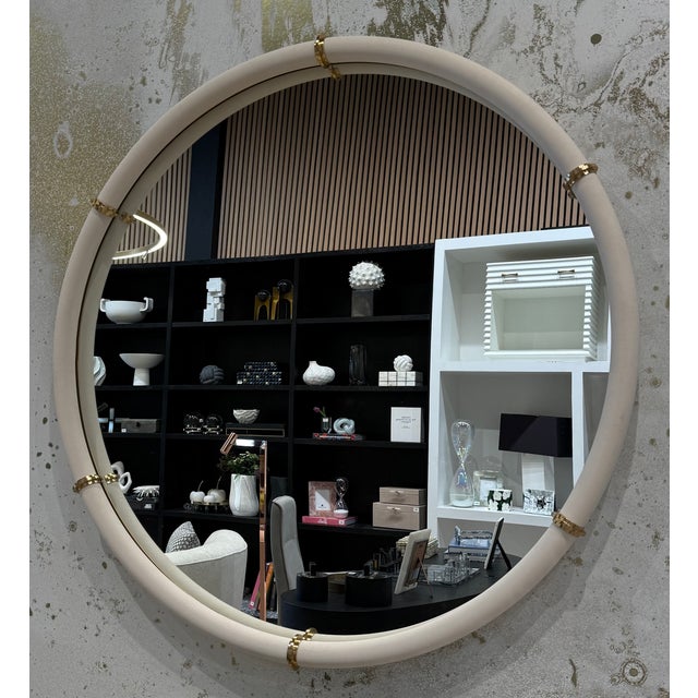 The Cyprus Round Mirror showcases a white faux shagreen leather wrap featuring brass-plated steel bands that help elevate...