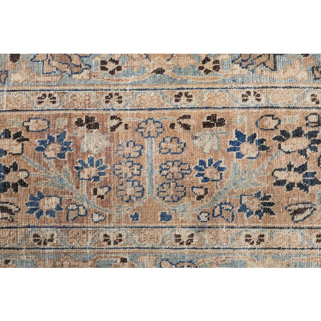 An early 20th century antique Persian Khorassan rug, the indigo blue field with a dense allover trellis of trees,...