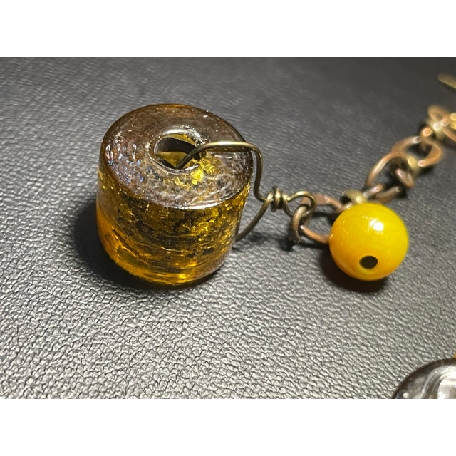 These early MCM (1930s-1950s) dangle earrings feature Venetian (Murano) glass wheel beads crafted with an internal gold...