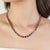 This refined tennis necklace is crafted in 925 sterling silver and set with 57 natural garnet gemstones, each beautifully...