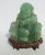 Chinese Green Fluorite Carved Figure of a seated Hotei. A massive chunk of this glowing greenstone and the happy figure of...