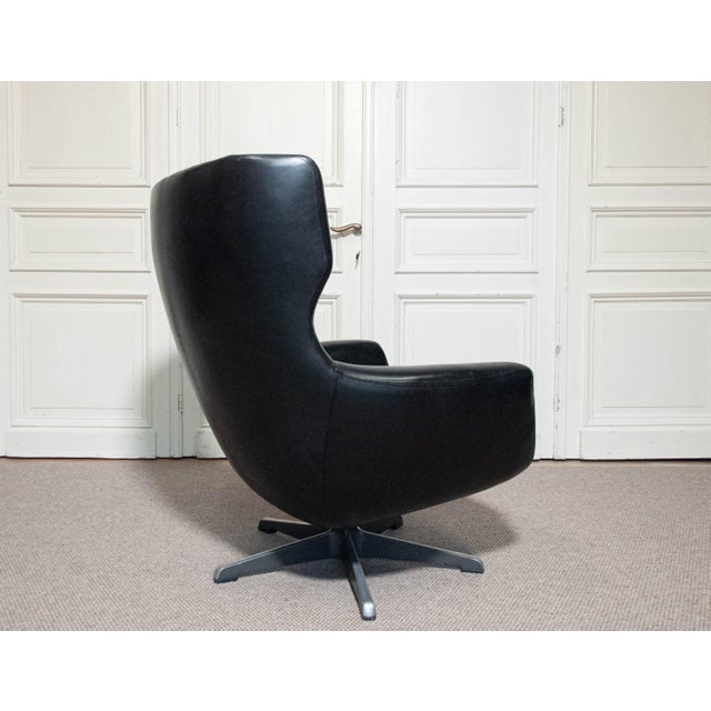 A striking black swivel lounge chair designed by h.w. Klein for bramin møbler, denmark. this sculptural chair features a...