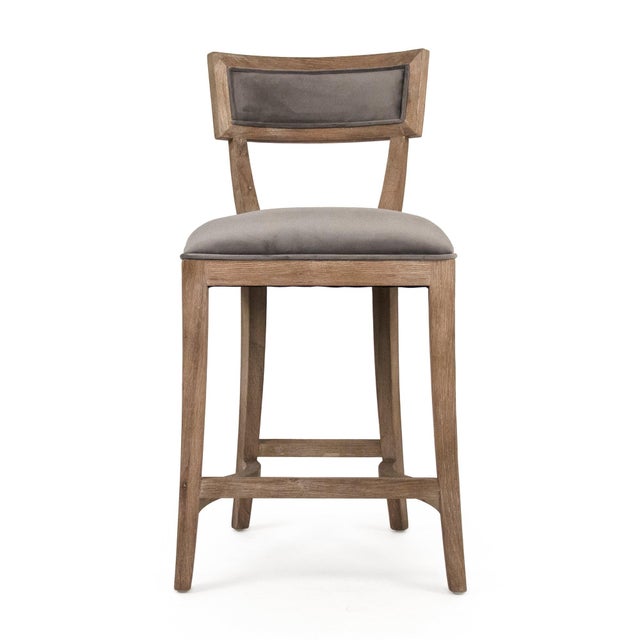 The Carvell Counter Stool from Zentique in grey velvet brings a contemporary edge to the klismos-inspired silhouette. The...