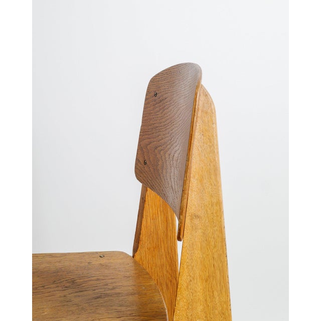A rare, early and iconic french mid century wooden "tout bois" dining chair in stained and molded oak plywood designed by...