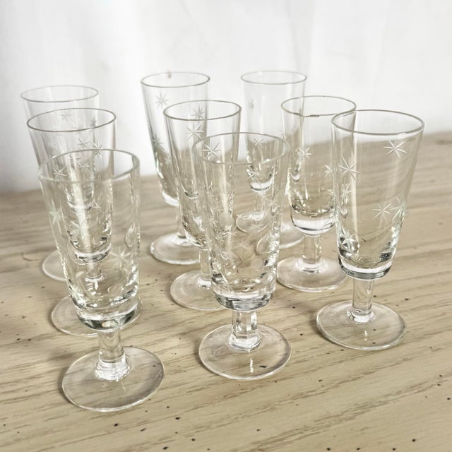 This elegant set of nine Mid-Century Modern sherry or shot glasses showcases classic starburst etching, a timeless motif...