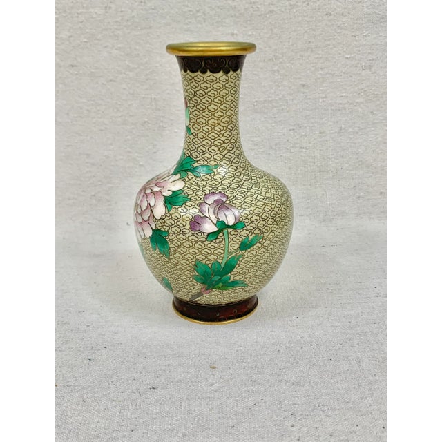 Beautiful vintage cloisonne vase. Floral detailing. Features several different flowers and a geometric pattern band on the...