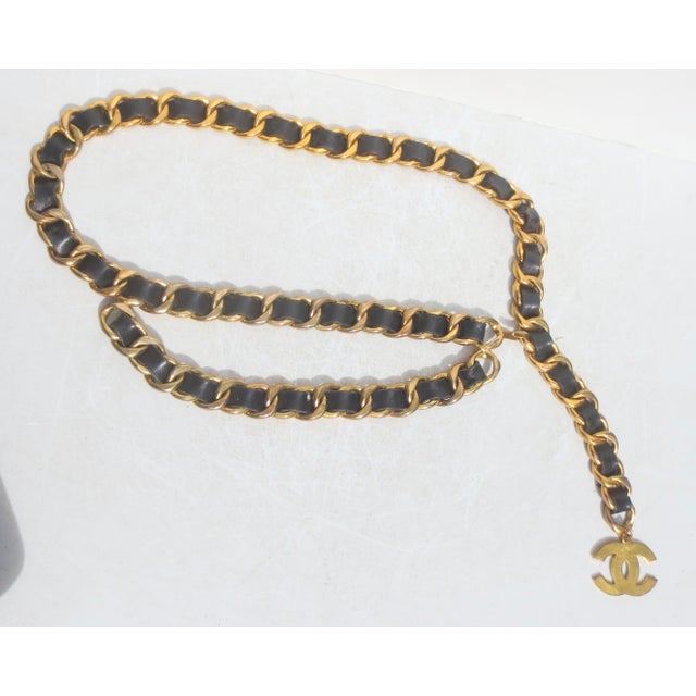 Chanel chain link belt with leather woven through the links. Closes by hook to link a wrap over the hip or across the...