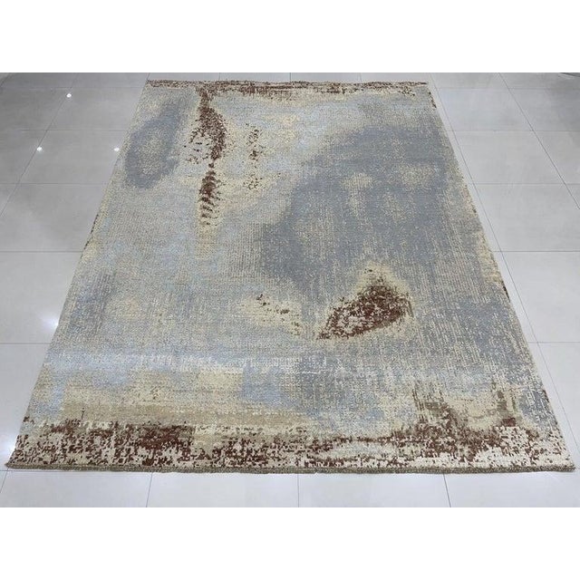 This gray wool rug features a hand knotted pile construction suitable for residential use. Following the style of EORC...