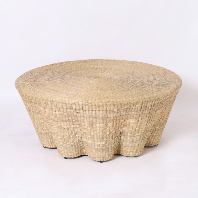In vogue coffee table handcrafted with a durable metal frame and wrapped in reed in a ghost drapery form.