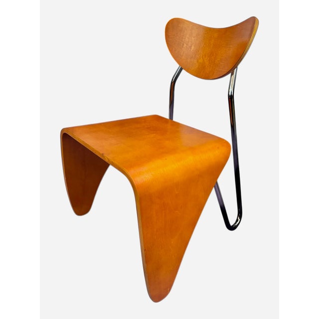 Embodying the sleek elegance of Scandinavian design, this Mid-Century Modern Danish Bentwood and Chrome Chair is a true...