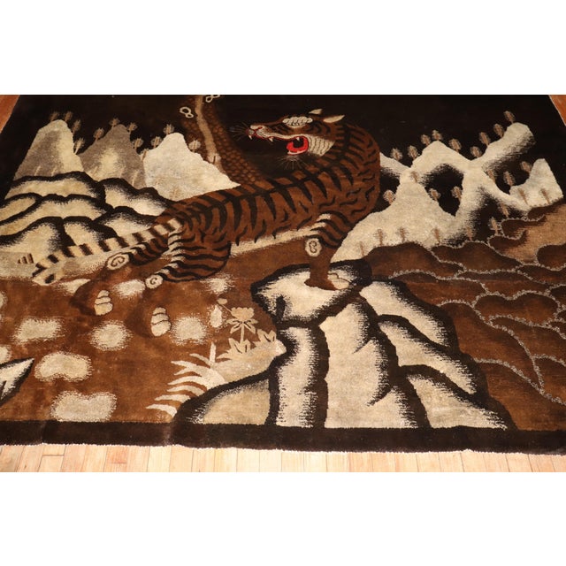.Rare early 20th century Chinese square rug feautring a large angry tiger in a scenic background , colors primarily in...