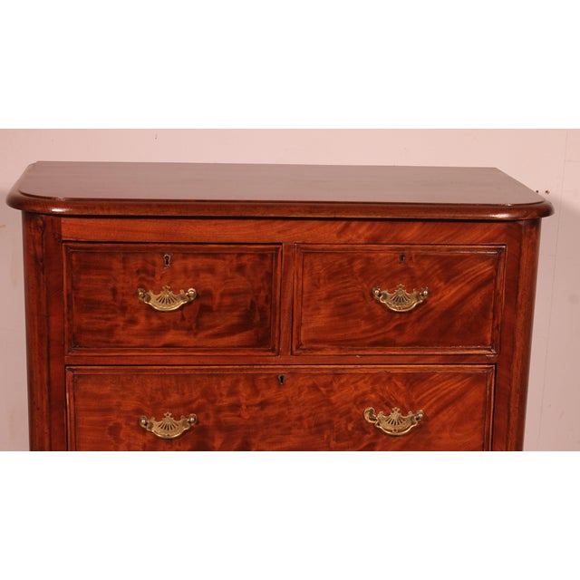 Charming small mahogany chest of drawers from 19th century England. Beautiful flame-like decoration on the drawers and...