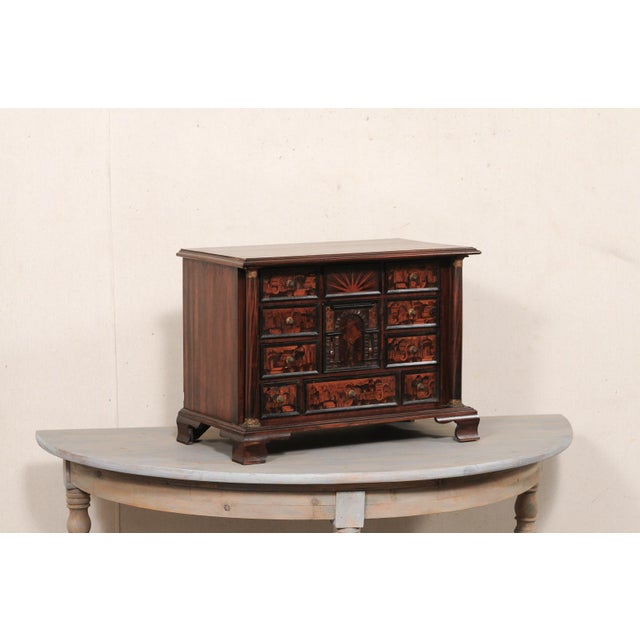 A small sized Italian table top chest from the early 20th century. This antique petite chest from Italy features a pair of...
