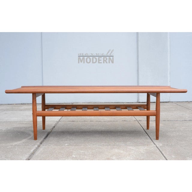Beautiful vintage mid century Danish coffee table from the 1960s. Made of teak wood with sculpted edges and a bottom...