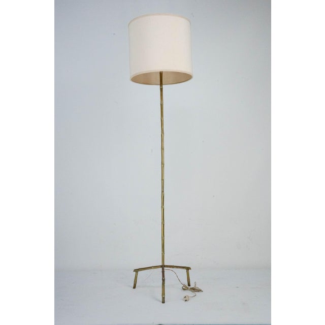 An elegant floor lamp originating from italy, circa 1960. This piece features a heavy, solid brass construction...