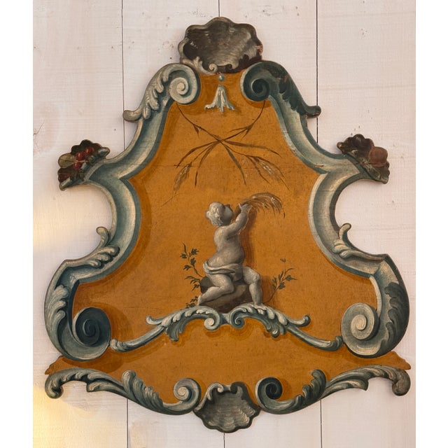 A vibrant 18th century Italian rococo panel with shaped silhouette, painted in ochre and celadon tones. The central...