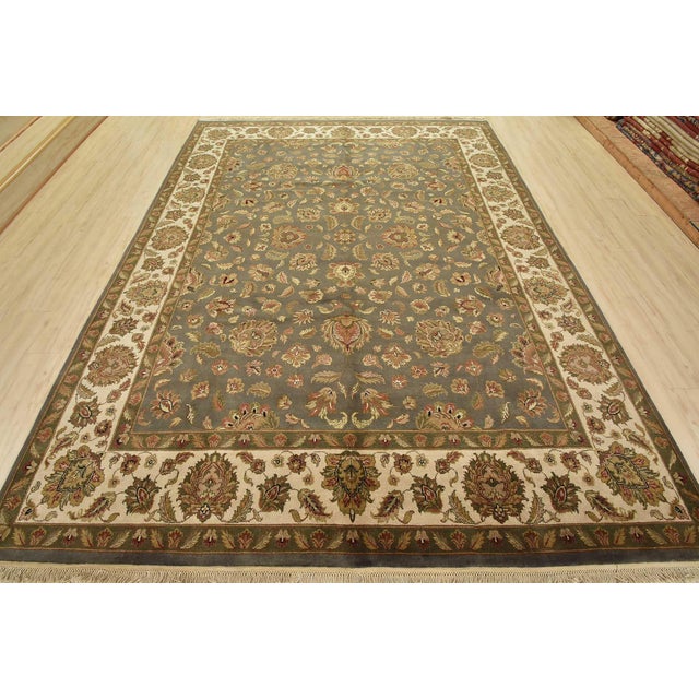 A traditional Agra rug is hand-knotted with fine wool on a cotton foundation. This area rug features a botanical design...