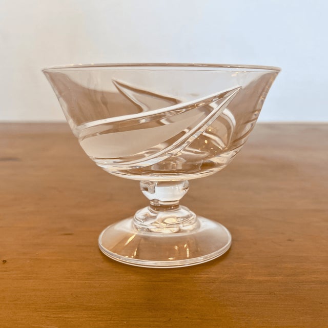 A striking mid-century crystal ensemble by Cristallerie de Lorraine, composed of eight coupe glasses encircling a...