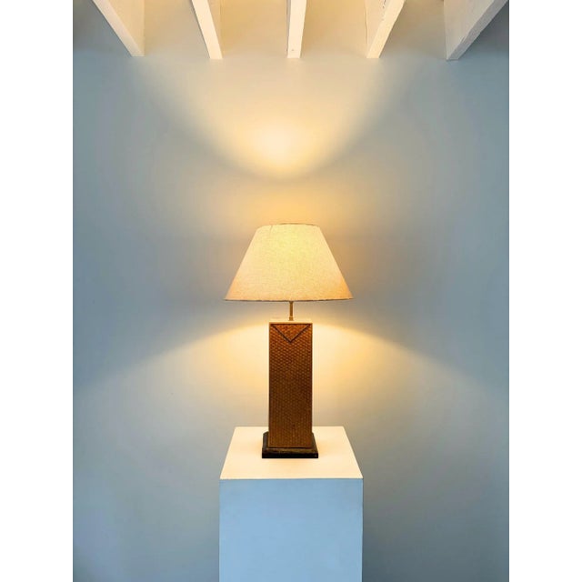 A decorative 20th century italian table lamp of cuboid form. This statuesque accent light features textural woven rattan...