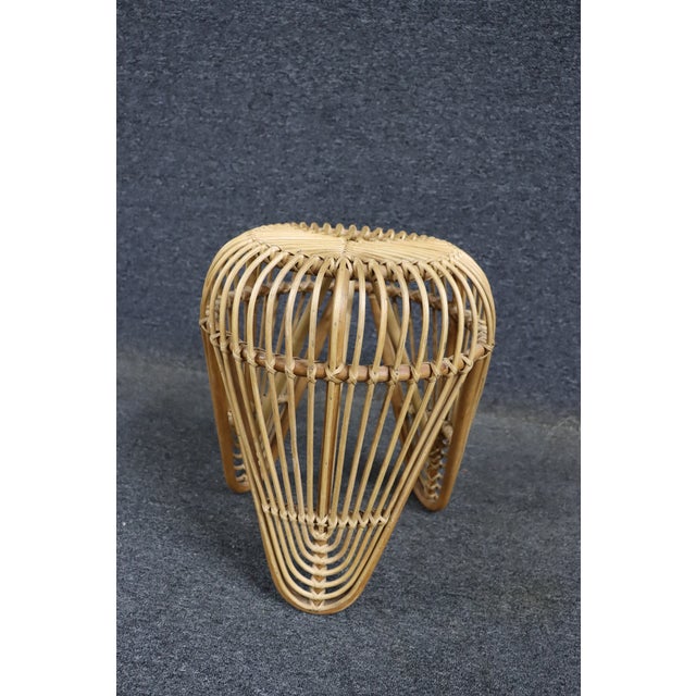 Mid-century rattan plant stand with an open woven design and tripod base. Lightweight and versatile, suitable for use as a...
