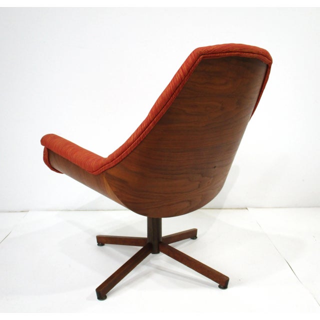 An exceptionally stunning very comfortable upholstered swiveling lounge chair with full bent walnut back and bottom....