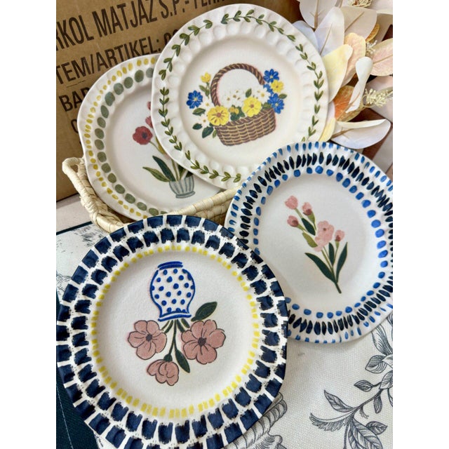 This is a set of four ceramic plates featuring exquisite floral patterns. These plates are a wonderful way to add color...