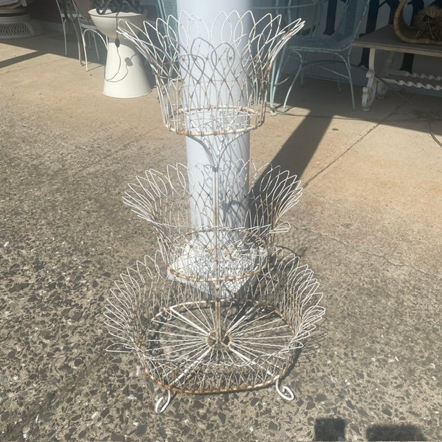 This is a white wire planter/display stand. Made of wire & metal. 4 scrolled feet. Very European/French style. No...