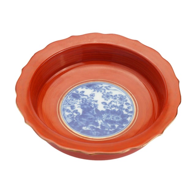 Japanese coral red enameled porcelain bottle coaster, with standing edge and flaring scolloped rim, centering on a...