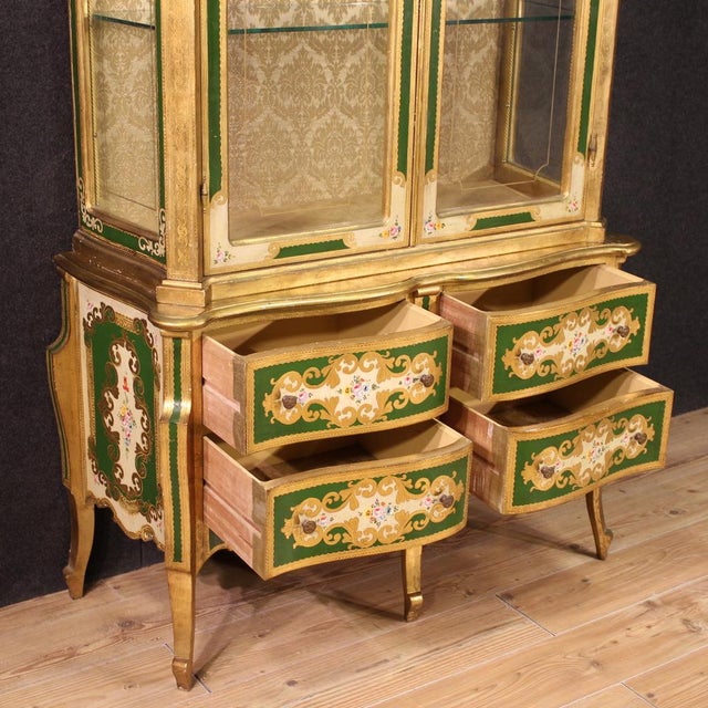 Florentine display cabinet from the mid-20th century. Richly lacquered, gilded and hand-painted with floral decorations of...
