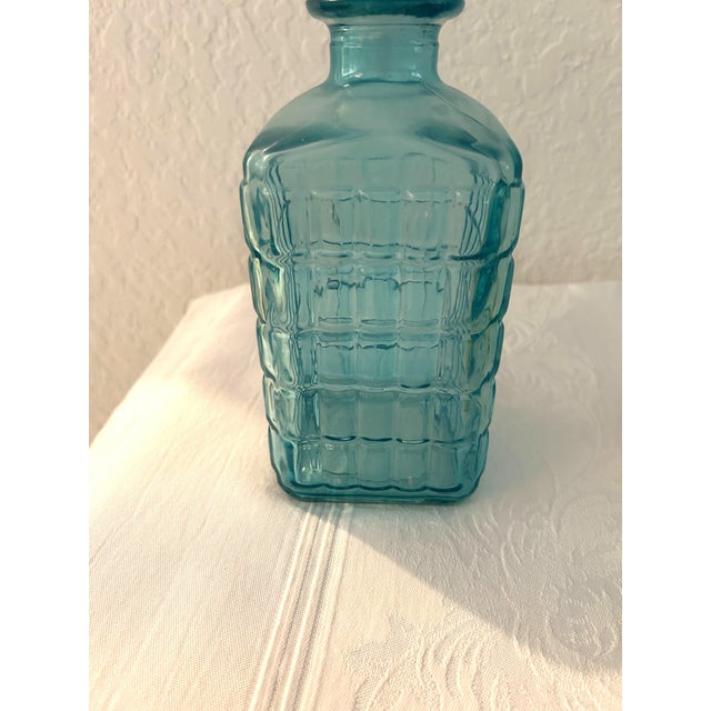 Colorful pair of vintage clear glass decanters in blue and Canary yellow in geometric designs. Each with plastic twist off...