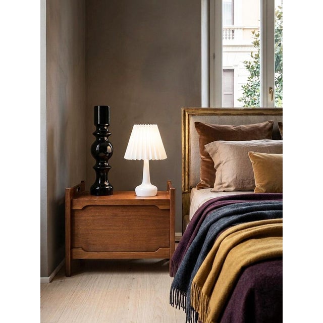 A pair of Saporiti teak nightstands from the 1960s, featuring a sedan-style structure with contoured sides and carved...