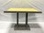Pair of cerused oak dining tables with yellow laquered top. The wood frame is stained Miniwax Classic Gray, while the top...