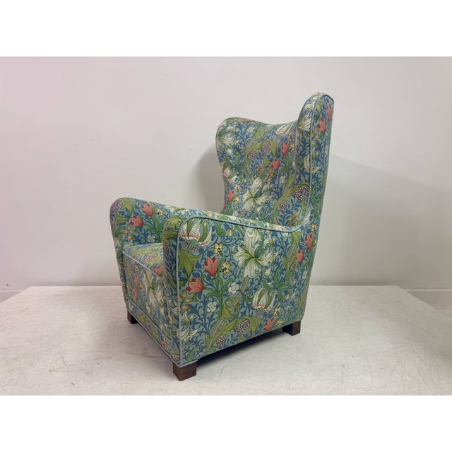 A Danish upholstered armchair, model 1672, produced by Fritz Hansen, mid-20th century. The chair features a generous,...