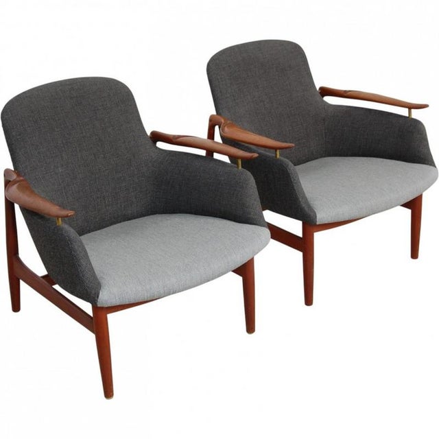 Set of 2 Finn Juhl NV53 lounge chairs, upholstered in grey fabric, and with armrests and legs of teak. The chairs are from...
