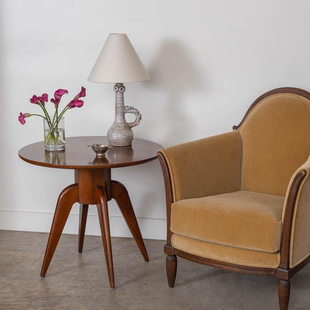 Beautiful wood side table from France, 1950s. Circular top rests on four tapered wood sculptural legs. Newly refinished in...