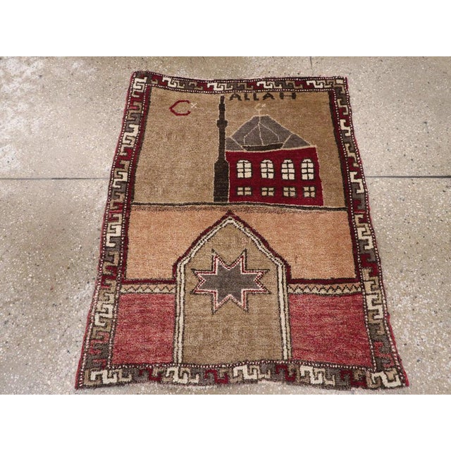 A vintage Turkish Anatolian pictorial rug. A mosque and minaret stand in the upper half of the field. An “Allah”...