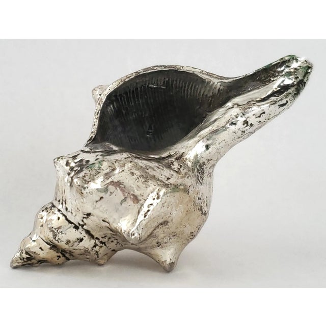 Offering a vintage conch shell dipped in a silver alloy, circa Late 20th Century. This gorgeous seashell is a REAL shell...