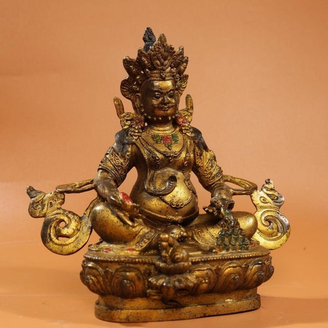 This is a finely crafted antique gilt bronze sculpture of Yellow Jambhala, the Buddhist deity of wealth and prosperity ....