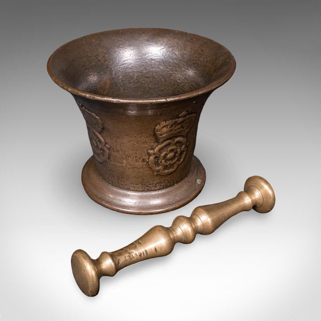 This is an antique apothecary mortar and pestle. An English, bronze kitchen or chemist's instrument with Tudor Rose motif,...