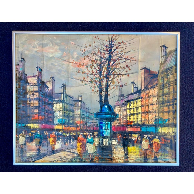 This impressionist-style Parisian street scene with a blue cologne Morris (a traditional advertising kiosk) and Haussmann-...