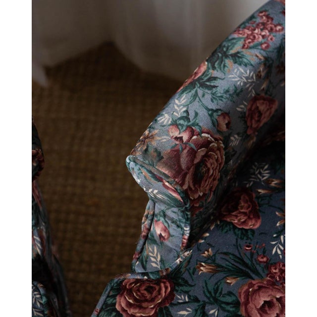 A unique pair of velvet floral lounge chairs with blues and pinks. The details at the top of each chair are lovely. Unmarked.