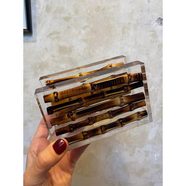A napkin or letter holder comprised of bamboo suspended in lucite, bearing its original Lane Crawford price tag.