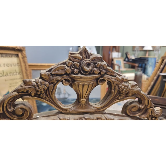 A large antique round 1920s mantle or wall mirror. Featuring a French style rope turned border culminating in a basket of...