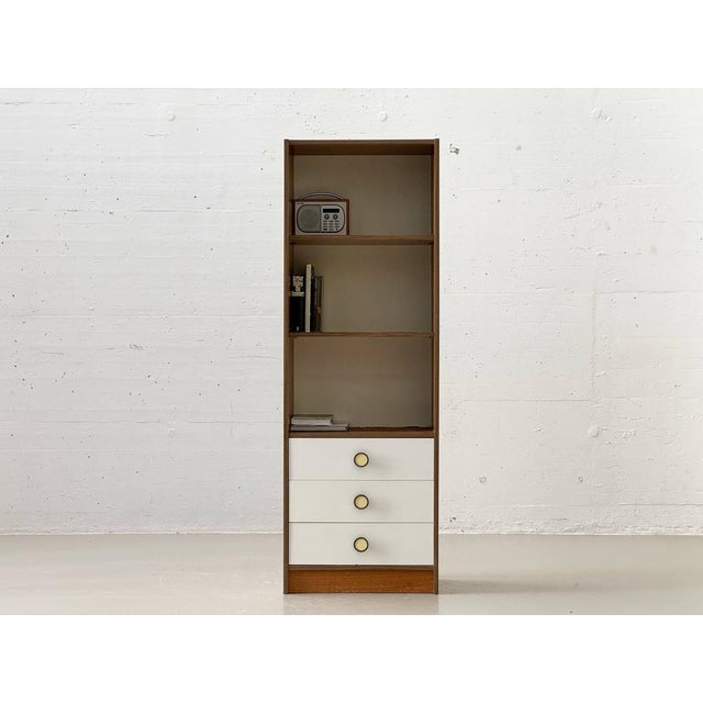 This elegant, slimly proportioned tall cabinet from the 1960s combines functional clarity with a warm, inviting appeal and...
