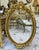 Magnificent French-style wall mirror featuring an elaborately hand-carved frame adorned with intricate floral motifs and...