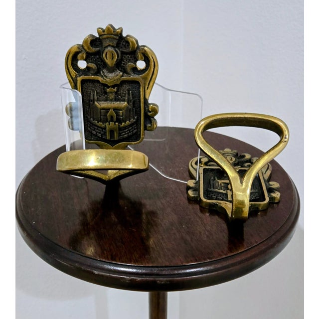 This elegant pair of vintage solid brass wall hangers features a striking Royal Coat of Arms motif, highlighted by a...