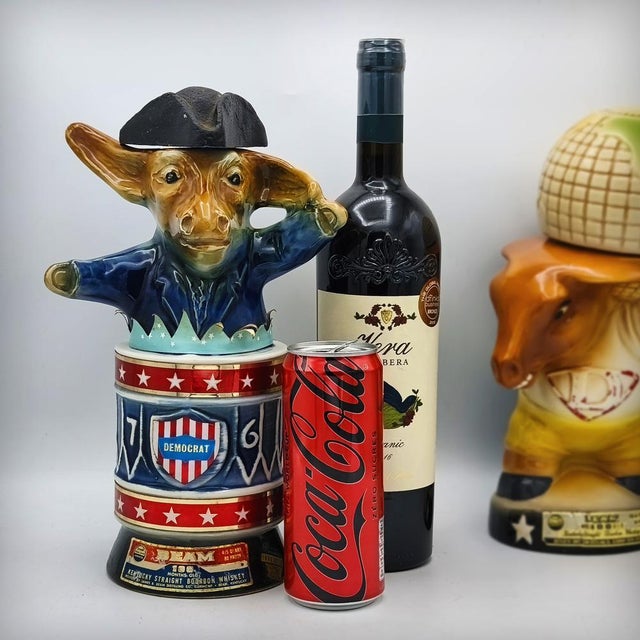 A ceramic decanter or bottle depicting a Democratic presidential donkey, produced and published by bourbon distiller Jim...