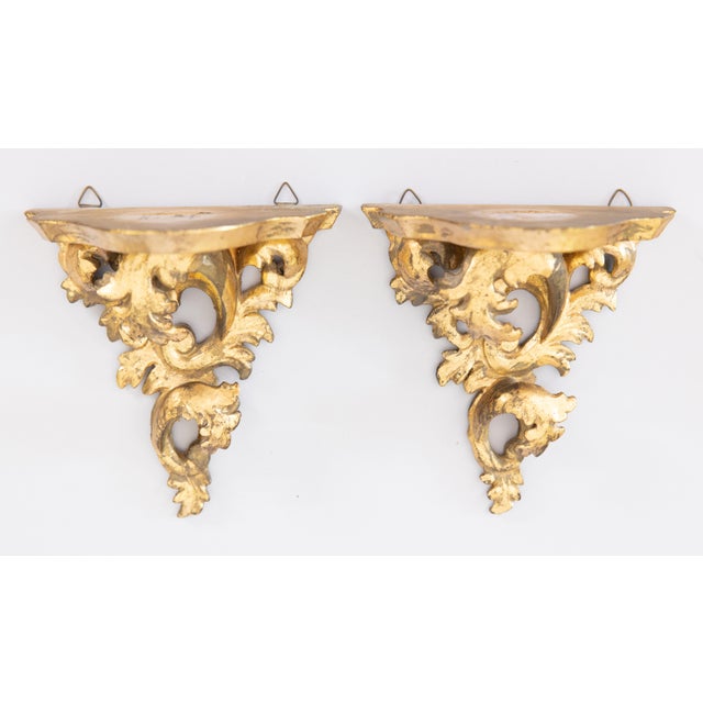 A lovely pair of Mid-Century Italian Florentine Rococo style gold leaf gilded wood wall brackets shelves, circa 1950....