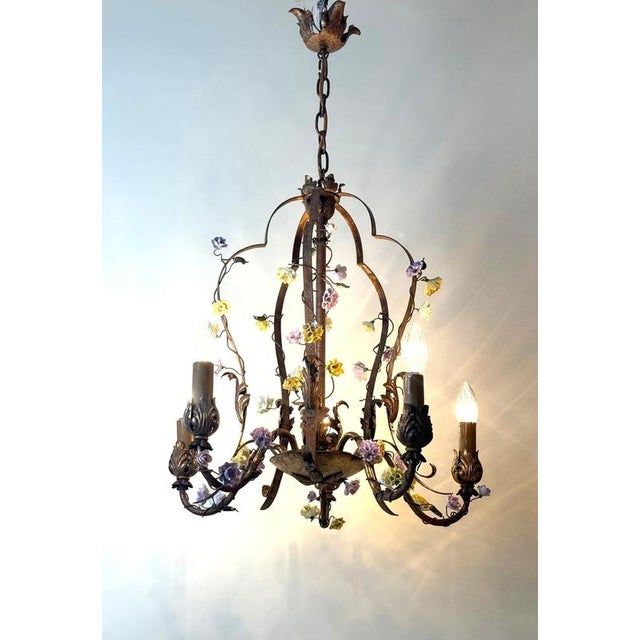 Italian Gilt Iron Five-Light Chandelier with Porcelain Flowers, circa 1930 This enchanting five-light chandelier was most...