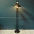 Vintage turn-of -the-century fine reproduction 1970s French Empire style black metal toleware floor lamp. It features...